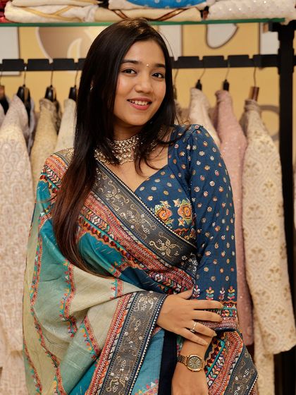 A closer look at the multi-colored lehenga, focusing on the floral embroidery on the blue blouse and the intricate patterns on the dupatta.