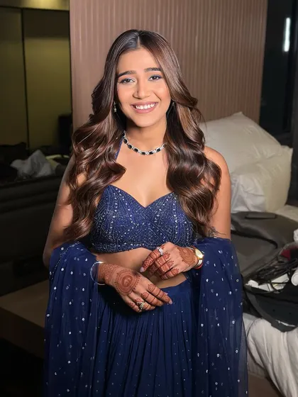 The complete look, showing the beautiful flow of her hair and the elegant simplicity of her navy blue outfit. It's a chic and modern choice.