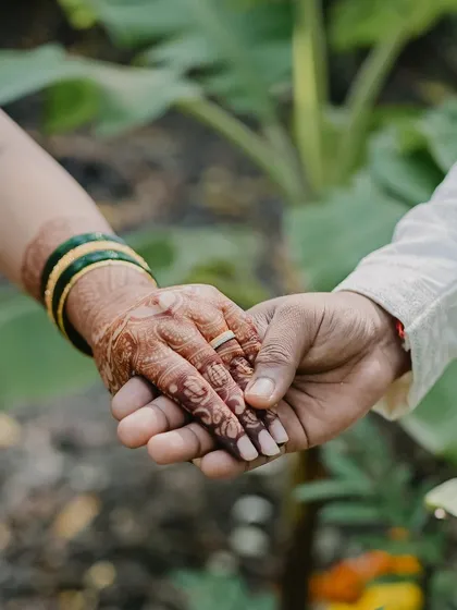 A candid shot of a couple holding hands, showcasing the beautiful, dark stain of the bride's mehendi. This is what I call stain goals.