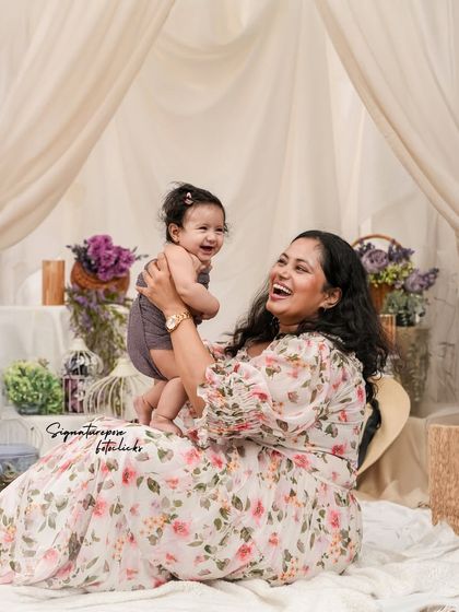 Pure happiness. A mother laughs while lifting her baby girl, a perfect example of the candid, joyful moments we strive to capture.