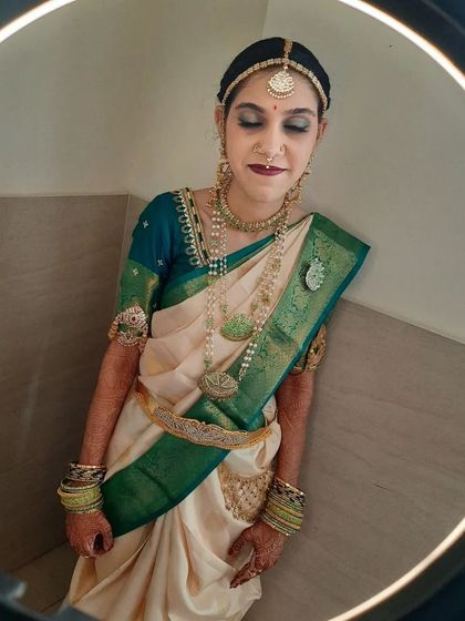A candid-style shot of the bride, showcasing how the makeup looks natural and not overly staged. The complete ensemble with the saree and jewellery comes together perfectly.