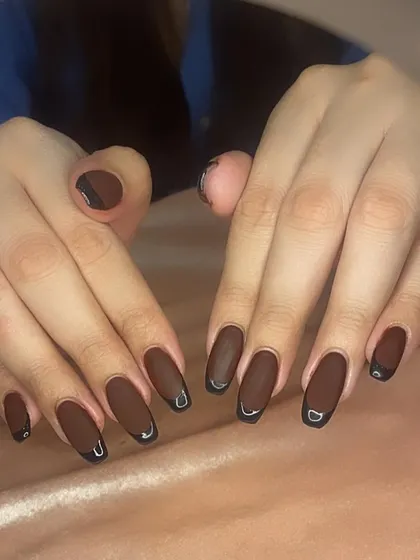 A matte brown French manicure with glossy black tips for a sophisticated, multi-textured look.