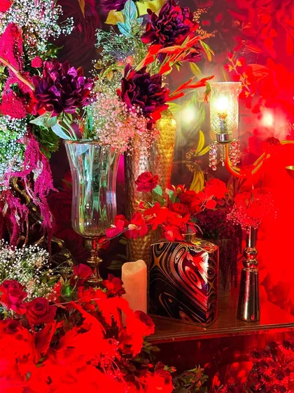 This masquerade-themed party was drenched in dramatic red lighting, with intricate floral centerpieces, candelabras, and even a mirrored mannequin adding to the mysterious and glamorous vibe.