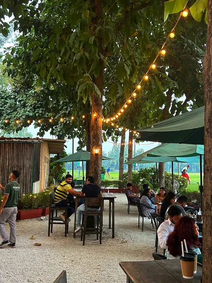 A view of the cafe from the side, showing the string lights and lively crowd.