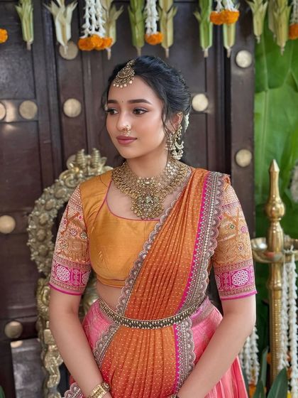 A side profile of the half saree look, showing the intricate hairstyle and jewellery details.
