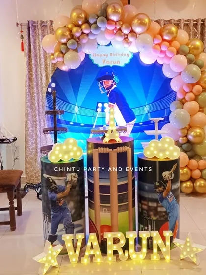 I design fully themed birthday decorations, like this cricket-themed setup for a young fan. The package includes a custom backdrop, themed pedestals for the cake, personalized marquee letters, and a matching balloon arch to bring the entire concept to life.
