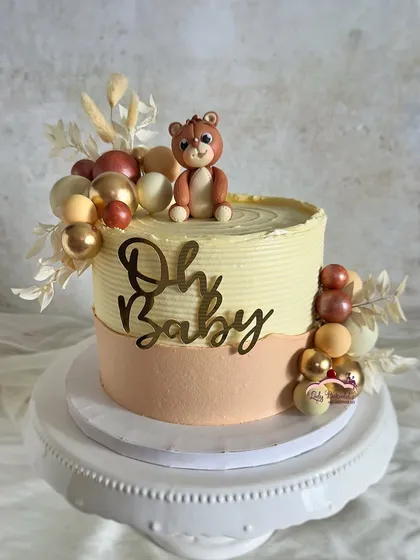 A teddy-fic cake for a baby shower! This design features a neutral color palette and a cute teddy bear topper.