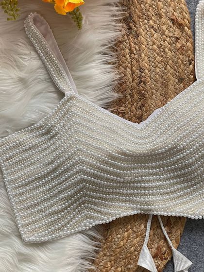 A close-up of the white pearl blouse, showing the texture and craftsmanship.