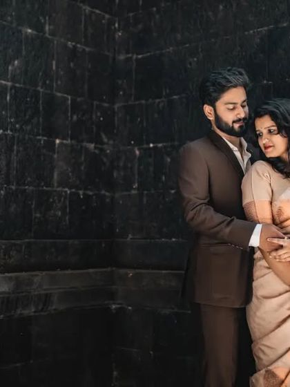 A dramatic and intimate portrait against a dark, textured wall. This kind of lighting and posing creates a sophisticated and modern pre-wedding look.