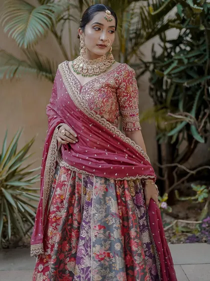 A beautiful outdoor shot of the floral lehenga. The natural light brings out the rich colors of the fabric and the intricacy of the embroidered blouse.