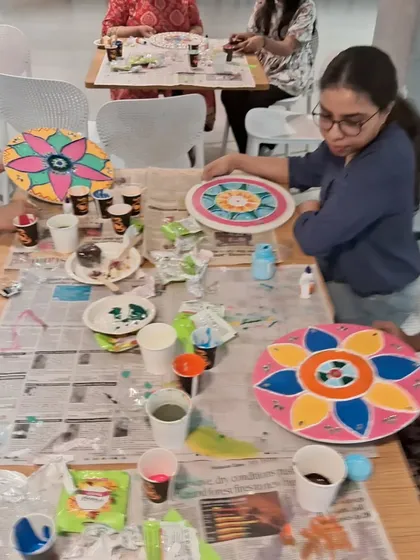 A table full of artists, each working on their own unique Lippan art design. Our workshops are a vibrant hub of creativity and shared learning.