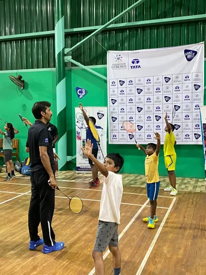 Young players practicing their overhead swings in unison, a drill designed to build muscle memory and proper technique.