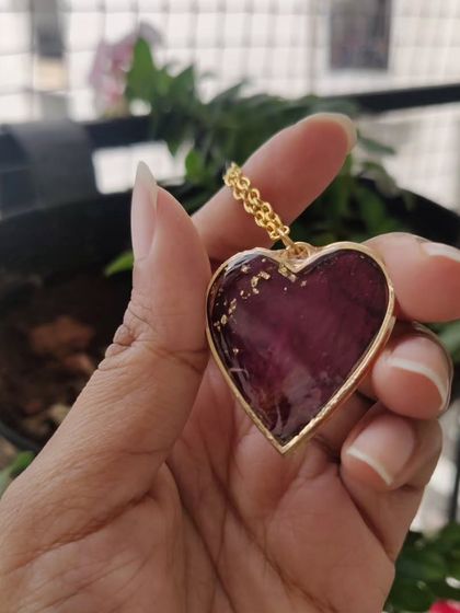 This matching jewelry set, a heart-shaped pendant and a ring, was created using a client's preserved rose petals. It's a beautiful way to keep a sentimental flower close to your heart.