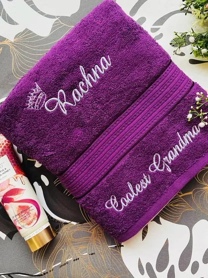 A gorgeous purple towel set, one embroidered with 'Rachna' and a crown, and the other with 'Coolest Grandma'. A perfect gift out of love and affection.