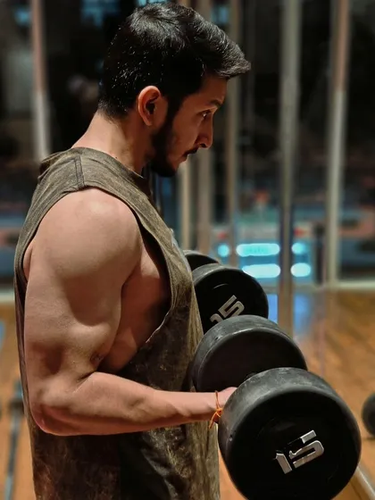 Hustle for that muscle. A close-up of a dumbbell curl, focusing on the bicep peak contraction.