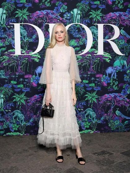 Another shot from the Dior show, showcasing the complete look against the iconic Dior backdrop. The hair and makeup were designed to feel romantic and timeless.