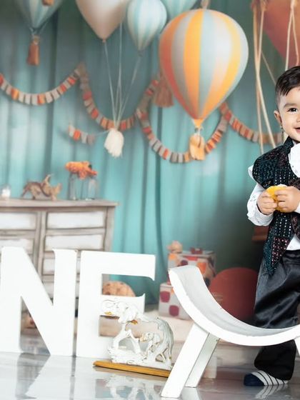 This little gentleman is looking dapper at his first birthday party, surrounded by hot air balloons and travel props.