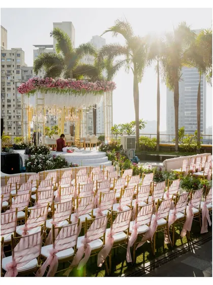 The stunning rooftop mandap setup at the St. Regis Mumbai for a 50th-anniversary celebration, with the city skyline in the background.