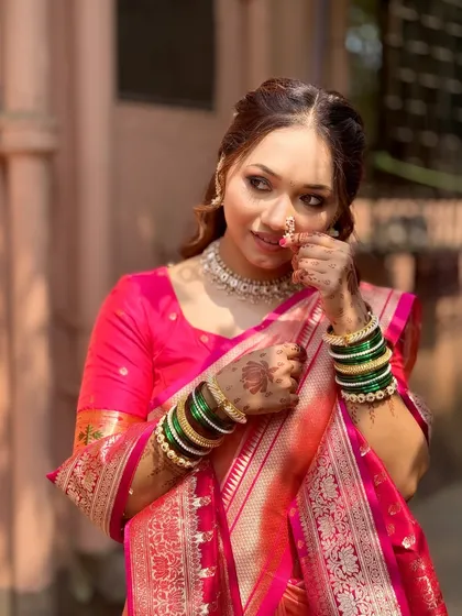 A close-up of her traditional engagement look, featuring a classic Maharashtrian nath and radiant makeup that glows in the natural sunlight.