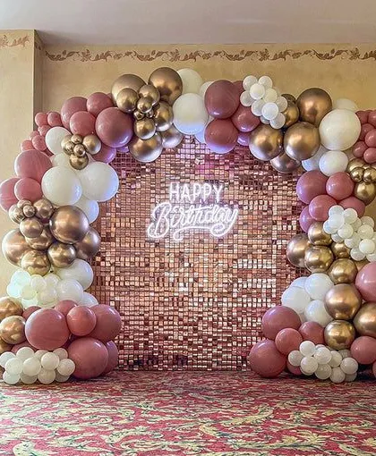 A beautiful rose gold sequin wall provides the perfect backdrop for this birthday celebration. The organic balloon arch in dusty pink, white, and chrome gold complements the setup perfectly.