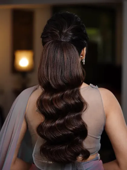 A voluminous, wavy ponytail is a perfect choice for a sangeet or reception. It's glamorous, fun, and keeps your hair off your face while you dance the night away.