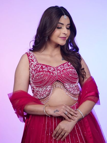 A close-up on the stunning beaded and fringed blouse of this hot pink lehenga. It’s the kind of detail that makes an outfit unforgettable.