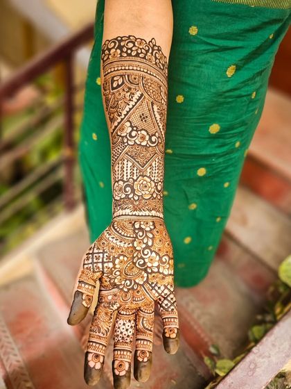 A full arm view of an intricate bridal design, with a mix of floral and geometric patterns.