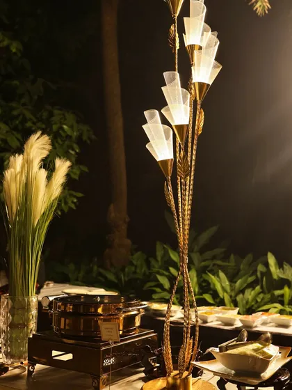 The decor and lighting are key elements of the ambiance I create. This elegant floor lamp and pampas grass arrangement add a touch of sophistication to the buffet setup.