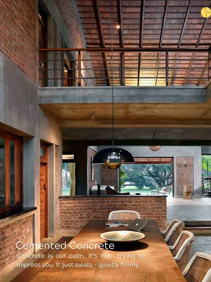 Concrete is our calm. It’s not trying to impress you; it just exists, quietly and firmly. In this dining space, the concrete wall provides a cool, neutral backdrop for the warm wood and woven chairs.