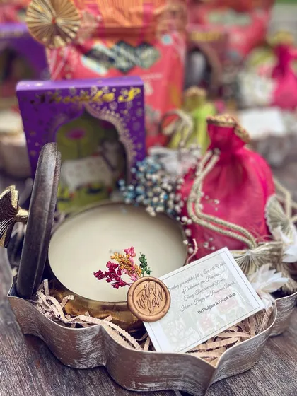 A close-up of a custom Diwali hamper. The hand-embroidered candle and "With Love" wax seal are central elements, showing how I focus on handcrafted details to make a gift feel special.