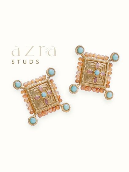 The Azra Studs feature intricate etched metalwork accented with colored semi-precious stones. They are a bold yet wearable choice for adding a touch of artisanal craft to your look.