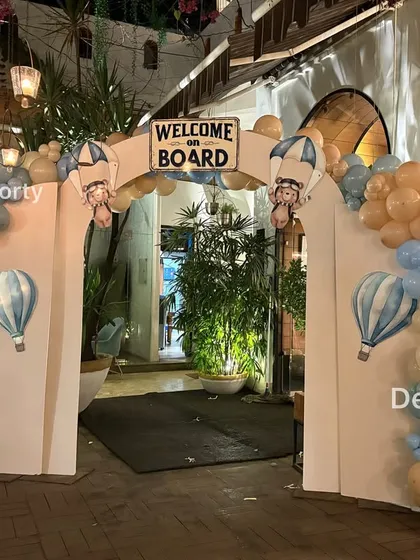 The "Welcome on Board" entrance arch adorned with a full balloon garland in pastel blue, tan, and white.