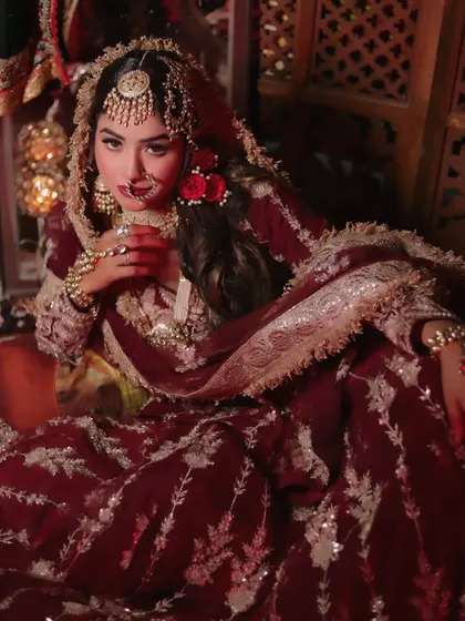 A full-seated portrait capturing the complete royal look, with layers of fabric and intricate jewelry.