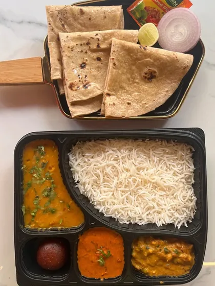 A classic North Indian thali in a box. This option includes dal, two vegetable preparations, paneer, rice, and rotis, making it a wholesome and traditional meal choice for any event.