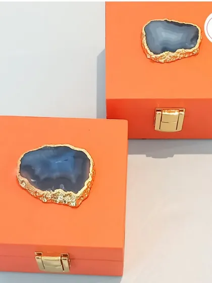 A unique favor box in a vibrant orange, topped with a beautiful agate stone slice. A modern and luxurious choice for wedding favors.