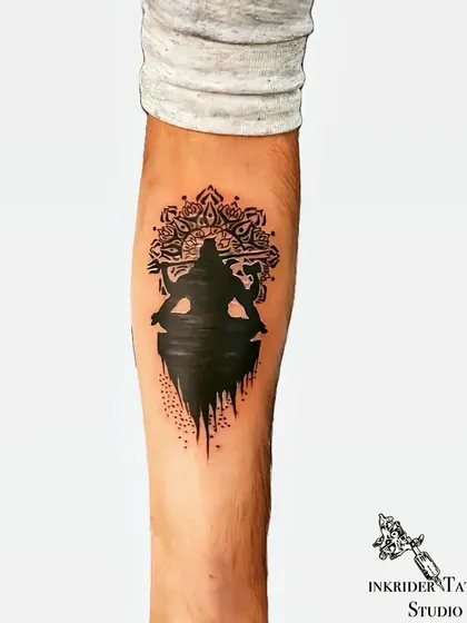 We concealed an old initial tattoo and surrounding scars with this powerful Mahadev silhouette. The design uses solid black ink and a detailed mandala background to create a bold statement piece on the forearm, completely hiding the previous ink.