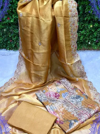 A gorgeous golden-yellow dress material set with a digital floral print top. The organza dupatta has a beautiful embroidered border, making it a luxurious choice for any celebration.