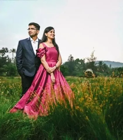 This elegant magenta gown with optional puff sleeves is perfect for an outdoor pre-wedding shoot in a natural, green setting.