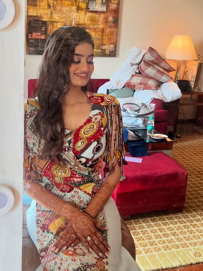 A mirror selfie of this gorgeous bride before her carnival event, showing off her soft waves and colorful outfit.