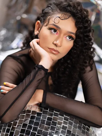 The art of eye contact. This editorial look features a neon graphic liner on a curly-haired model, creating a modern, edgy, and high-fashion aesthetic.