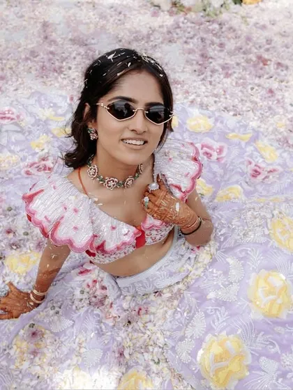 A fun and unique shot of the bride sitting in a sea of flower petals. Her cool sunglasses and relaxed pose capture the playful vibe of the day.