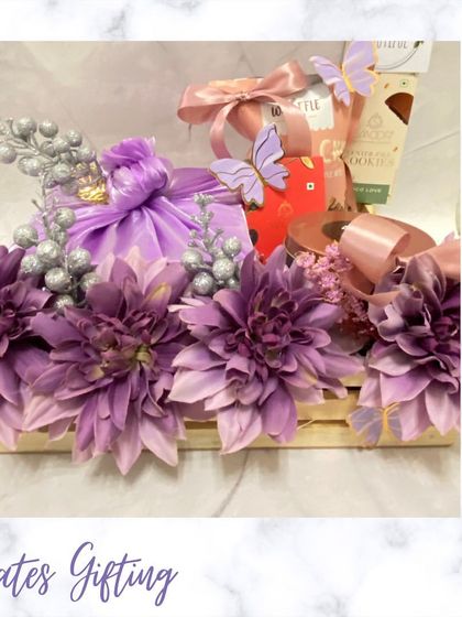 A beautiful floral crate hamper in shades of purple. The wooden crate is overflowing with flowers and gifts, creating a lush and luxurious feel.