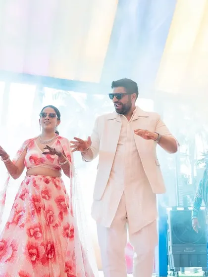 A grand carnival entry for a fun-loving couple. Surrounded by professional dancers in vibrant costumes, their entrance was a burst of energy and color.
