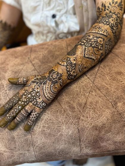 A full-arm design with heavy, intricate work, perfect for a bride who wants a traditional and bold look.