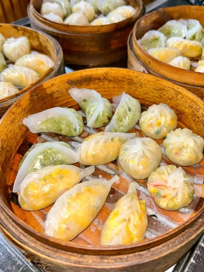 A beautiful assortment of freshly steamed dim sum in bamboo baskets. The variety in shapes and fillings is a key feature of my dim sum station.