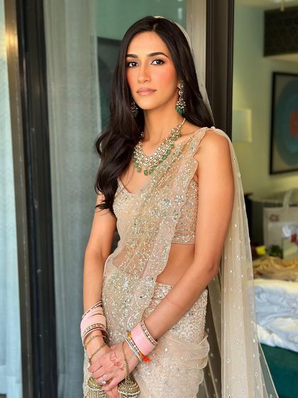 This bride, a film director from LA, prioritized minimalism. I created a very natural, fresh-faced look to complement her sparkling Sawan Gandhi saree, proving that less can be more.