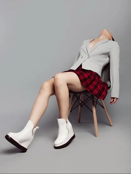 Lookbook styling for a shoe label, where I paired chunky white platform boots with a plaid skirt and a grey blazer. The pose and composition create a rebellious, preppy-punk aesthetic that is both playful and edgy.