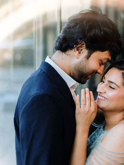 A beautifully lit close-up with a creative lens flare effect. This shot focuses on the tender and happy expression of the couple during their city pre-wedding session.
