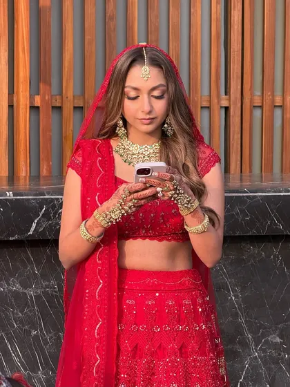 A candid moment captured during golden hour in Dehradun. The warm light beautifully highlights the golden and red tones in her makeup, creating a magical, glowing effect that every bride dreams of.