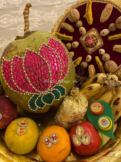 A close-up of an Oti basket featuring a coconut decorated with a beautiful pink lotus design made of kundan stones. We can customize these designs based on your theme.